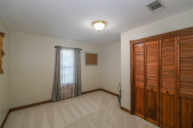 4746 County Road 502d, Sweeny, TX 77480 - unfurnished bedroom featuring light carpet, a closet, baseboards, and a textured ceiling
