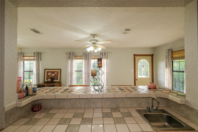 4746 County Road 502d, Sweeny, TX 77480 - kitchen featuring a sink, tile countertops, ceiling fan, and a textured ceiling