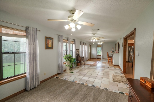 4746 County Road 502d, Sweeny, TX 77480 - foyer featuring light tile patterned floors, a ceiling fan, baseboards, and a textured ceiling