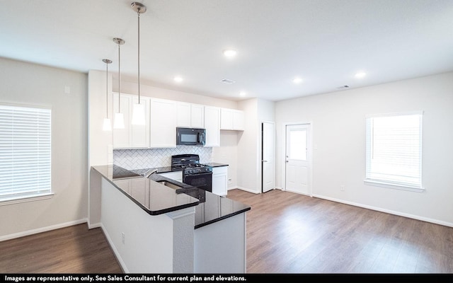 3527 Prairie Rose Trl, Angleton, TX 77515 - kitchen with black appliances, dark countertops, wood finished floors, decorative backsplash, and white cabinetry