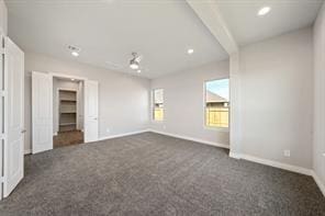 9314 Brunel Ln, Houston, TX 77044 - unfurnished bedroom featuring dark colored carpet, baseboards, recessed lighting, and a walk in closet