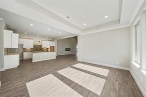 9314 Brunel Ln, Houston, TX 77044 - unfurnished living room with recessed lighting, a tray ceiling, dark wood finished floors, and baseboards