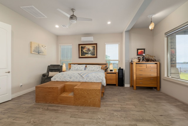 9314 Brunel Ln, Houston, TX 77044 - bedroom with an AC wall unit, wood finished floors, recessed lighting, and ceiling fan