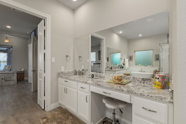 9314 Brunel Ln, Houston, TX 77044 - ensuite bathroom featuring a tub to relax in, vanity, wood finished floors, a shower stall, and recessed lighting
