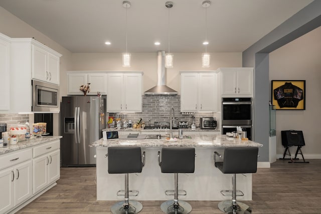 9314 Brunel Ln, Houston, TX 77044 - kitchen with stainless steel appliances, wall chimney exhaust hood, decorative backsplash, white cabinets, and a kitchen breakfast bar