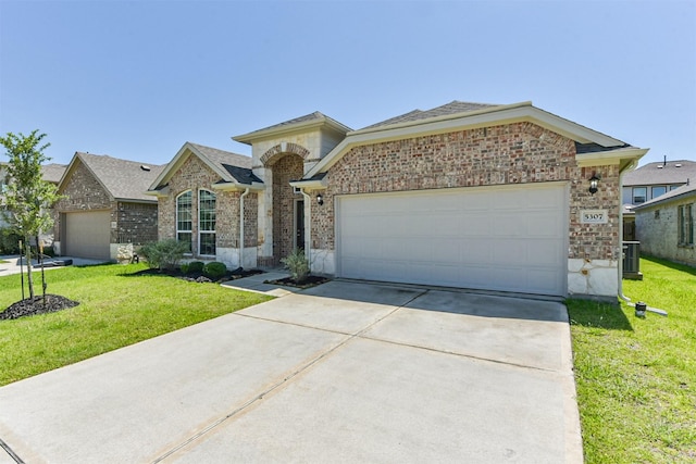 5307 Cascade Ct, Alvin, TX 77511 - view of front of house with a front yard, driveway, a garage, and brick siding