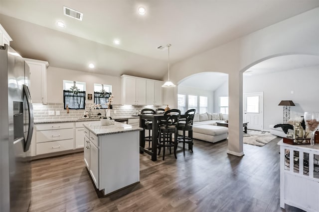 5307 Cascade Ct, Alvin, TX 77511 - kitchen with stainless steel fridge, open floor plan, arched walkways, vaulted ceiling, and backsplash
