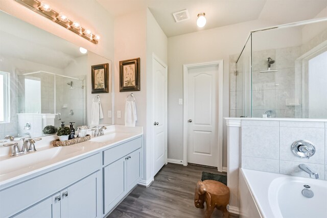 5307 Cascade Ct, Alvin, TX 77511 - bathroom with a stall shower, a garden tub, double vanity, and wood finished floors