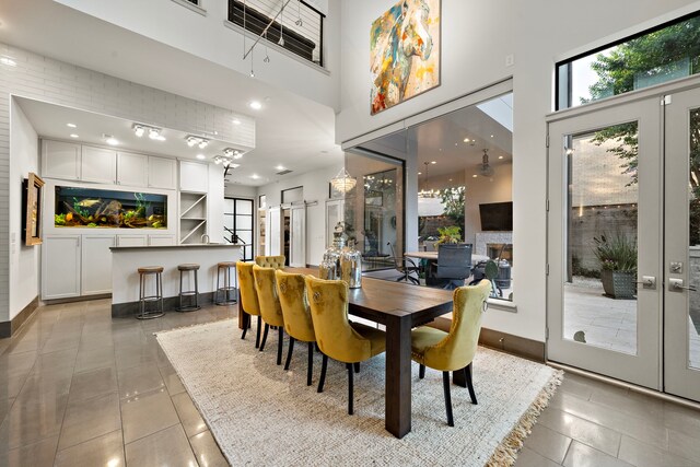 507 Terrace Dr, Houston, TX 77007 - dining space featuring light tile patterned floors, a high ceiling, healthy amount of natural light, baseboards, and recessed lighting