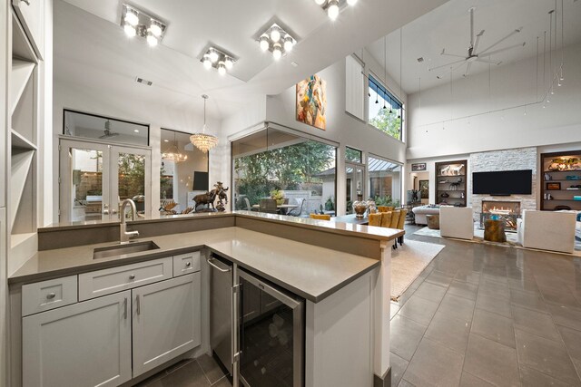 507 Terrace Dr, Houston, TX 77007 - kitchen with a sink, wine cooler, built in shelves, ceiling fan, and tile patterned flooring