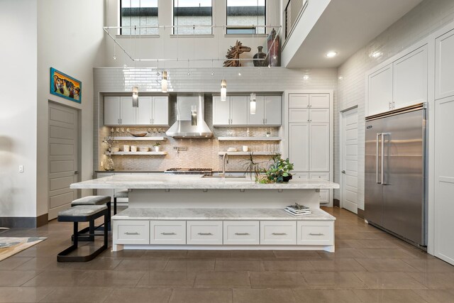 507 Terrace Dr, Houston, TX 77007 - kitchen with stainless steel appliances, wall chimney range hood, a high ceiling, a sink, and tasteful backsplash