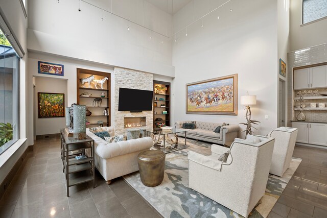 507 Terrace Dr, Houston, TX 77007 - tiled living room featuring a towering ceiling, healthy amount of natural light, built in shelves, and a fireplace