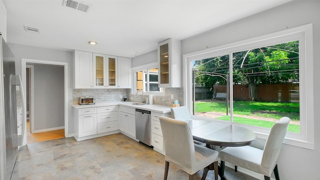 6805 Mobud Dr, Houston, TX 77074 - kitchen with stainless steel dishwasher, a sink, backsplash, light countertops, and glass insert cabinets