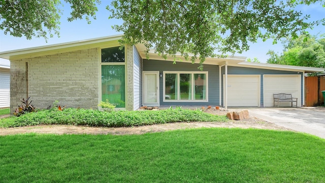 6805 Mobud Dr, Houston, TX 77074 - mid-century modern home featuring concrete driveway, a garage, and a front yard