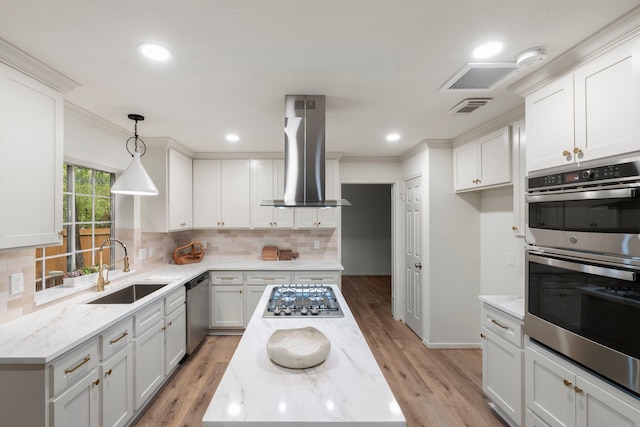 150 Rushwing Pl, The Woodlands, TX 77381 - kitchen with stainless steel appliances, island range hood, a sink, light stone counters, and backsplash