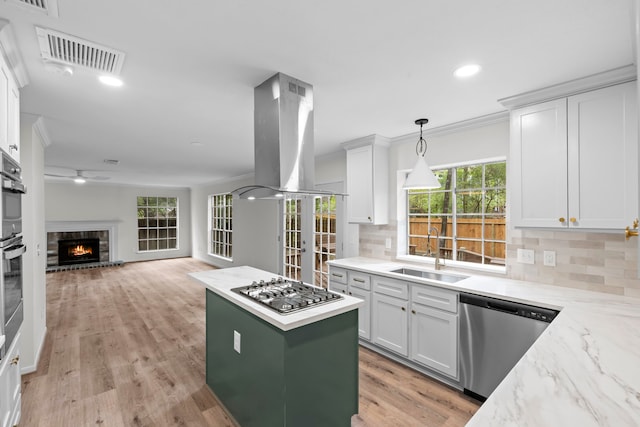 150 Rushwing Pl, The Woodlands, TX 77381 - kitchen with a sink, appliances with stainless steel finishes, island exhaust hood, white cabinets, and recessed lighting