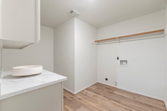 150 Rushwing Pl, The Woodlands, TX 77381 - washroom featuring hookup for an electric dryer, washer hookup, light wood-type flooring, and baseboards
