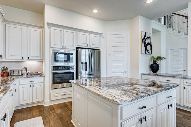 705 Serenity View Ln, Katy, TX 77493 - kitchen featuring stainless steel appliances, dark wood-style flooring, a kitchen island, light stone countertops, and recessed lighting