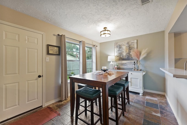 22410 Millgate Dr, Spring, TX 77373 - dining area featuring baseboards, a textured ceiling, and stone tile flooring