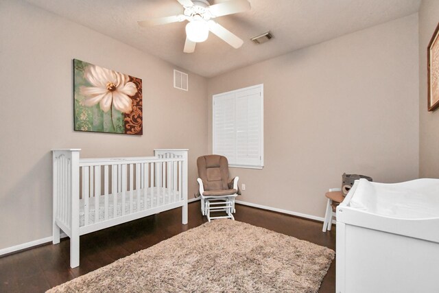 9510 Willowbridge Park Blvd, Houston, TX 77064 - bedroom with a nursery area, baseboards, dark wood-style floors, and ceiling fan