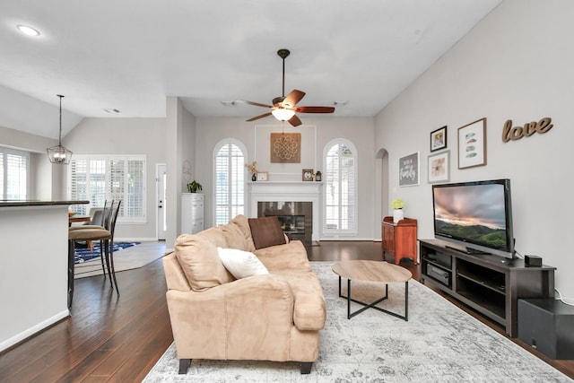 9510 Willowbridge Park Blvd, Houston, TX 77064 - living room with arched walkways, dark wood finished floors, a tiled fireplace, baseboards, and vaulted ceiling
