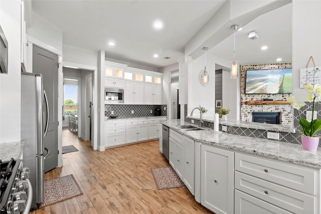 18327 Cypress Hill Dr, Rosharon, TX 77583 - kitchen featuring a sink, stainless steel appliances, backsplash, white cabinets, and light stone counters