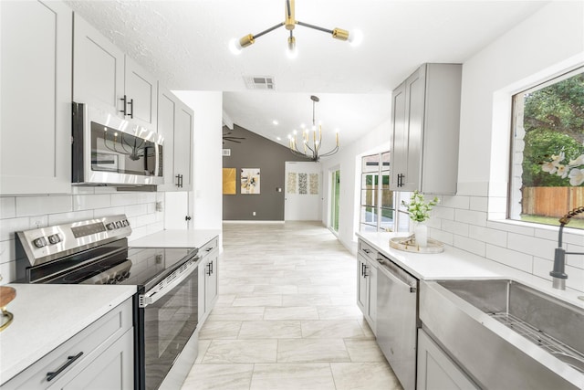 10530 Tenneco Dr, Houston, TX 77099 - kitchen featuring stainless steel appliances, a chandelier, a sink, plenty of natural light, and lofted ceiling