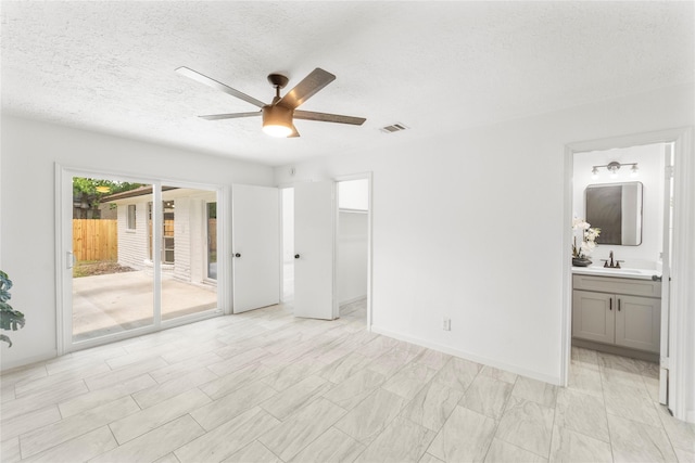 10530 Tenneco Dr, Houston, TX 77099 - unfurnished bedroom featuring access to exterior, a sink, a textured ceiling, connected bathroom, and ceiling fan