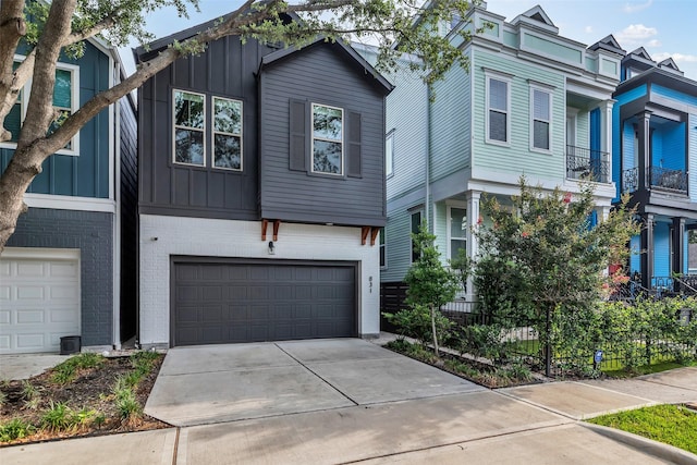 831 E 26th St, Houston, TX 77009 - view of front of home with board and batten siding, a garage, concrete driveway, and brick siding