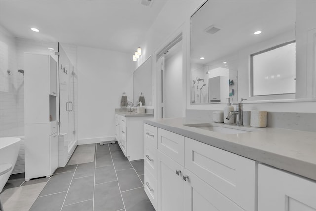 831 E 26th St, Houston, TX 77009 - bathroom with a stall shower, two vanities, tile patterned flooring, recessed lighting, and a soaking tub