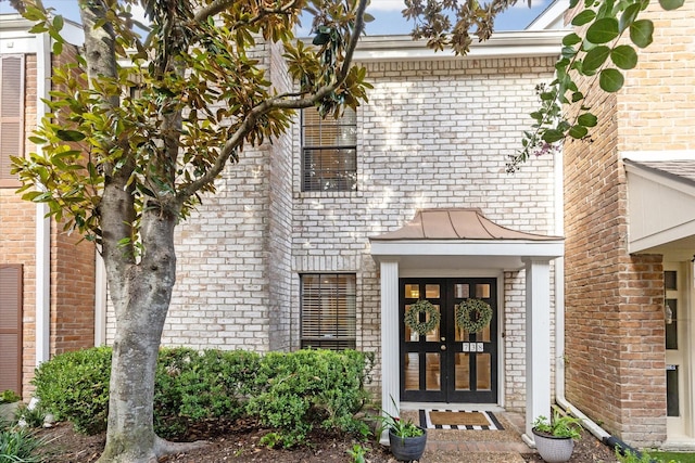 738 Augusta Dr Unit 312, Houston, TX 77057 - view of exterior entry with brick siding, a standing seam roof, and metal roof