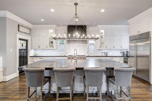 1811 Harvard St, Houston, TX 77008 - kitchen with built in fridge, decorative backsplash, white cabinets, a chandelier, and recessed lighting