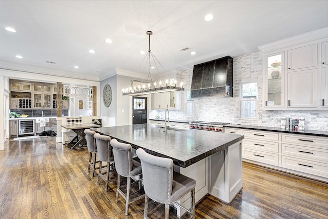 1811 Harvard St, Houston, TX 77008 - kitchen featuring custom exhaust hood, dark countertops, beverage cooler, crown molding, and backsplash