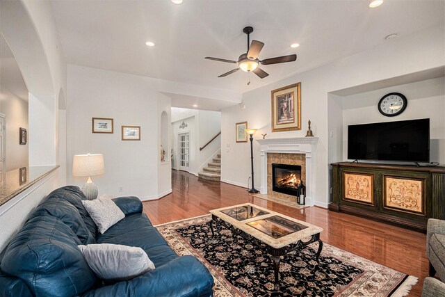 12631 Midland Creek Dr, Tomball, TX 77377 - living area with arched walkways, ceiling fan, stairway, wood finished floors, and a tile fireplace