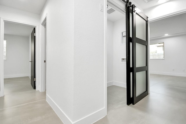 8906 Enchanted Forest Dr, Houston, TX 77088 - corridor with finished concrete flooring, a barn door, recessed lighting, and baseboards