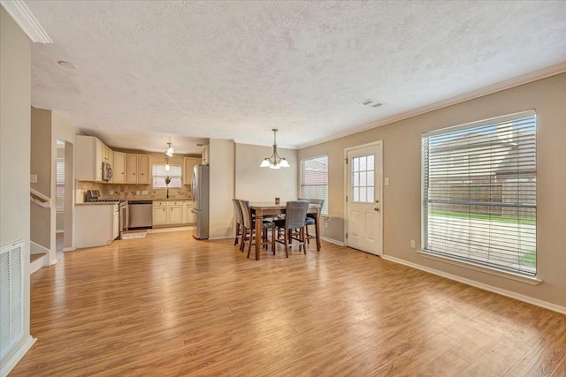 4235 Park Ridge Dr, Pasadena, TX 77504 - dining room featuring light wood-style floors, a chandelier, a textured ceiling, crown molding, and stairway