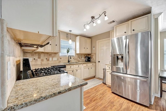 4235 Park Ridge Dr, Pasadena, TX 77504 - kitchen with stainless steel refrigerator with ice dispenser, light wood finished floors, tasteful backsplash, gas stove, and light stone countertops