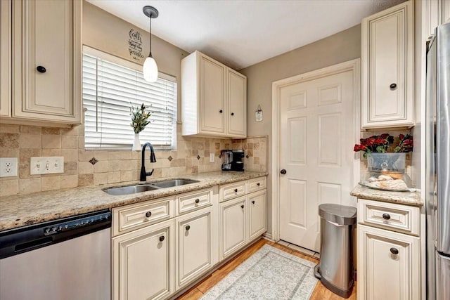 4235 Park Ridge Dr, Pasadena, TX 77504 - kitchen featuring appliances with stainless steel finishes, cream cabinets, decorative backsplash, pendant lighting, and light wood-style floors