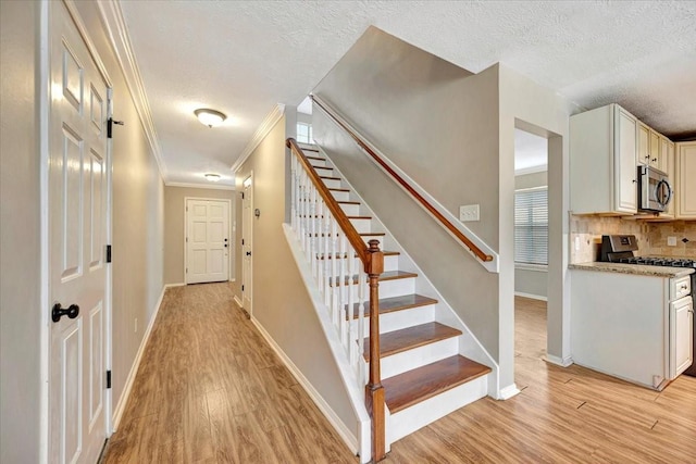 4235 Park Ridge Dr, Pasadena, TX 77504 - staircase featuring a textured ceiling, crown molding, and wood finished floors