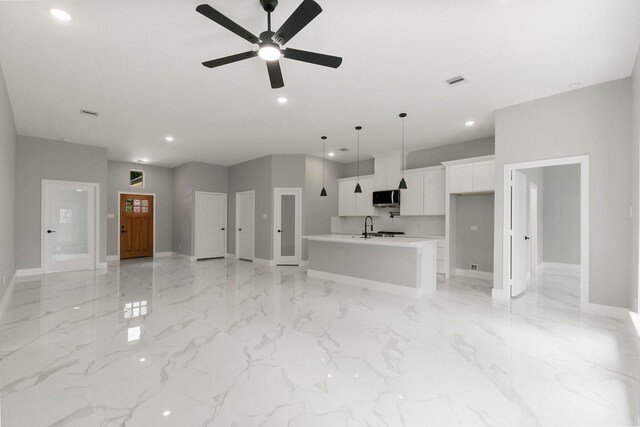3518 Misty Moss, Montgomery, TX 77356 - unfurnished living room with baseboards, recessed lighting, a ceiling fan, light marble finish flooring, and a sink