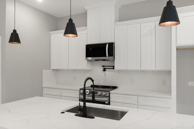 3518 Misty Moss, Montgomery, TX 77356 - kitchen featuring appliances with stainless steel finishes, backsplash, white cabinets, and light stone counters