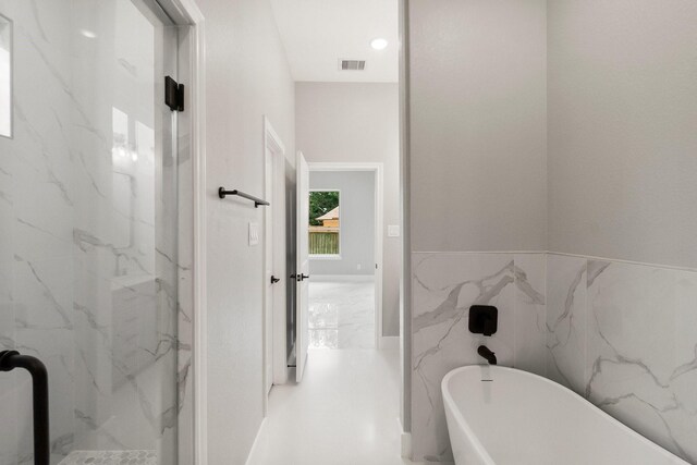 3518 Misty Moss, Montgomery, TX 77356 - bathroom featuring a freestanding tub, a marble finish shower, marble finish flooring, and wainscoting