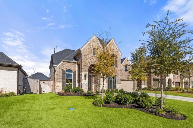 454 Patina Dr, Montgomery, TX 77316 - french country style house with brick siding, concrete driveway, stone siding, and a shingled roof