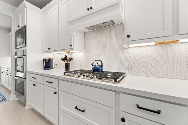 454 Patina Dr, Montgomery, TX 77316 - kitchen featuring custom exhaust hood, stainless steel appliances, tasteful backsplash, and light countertops