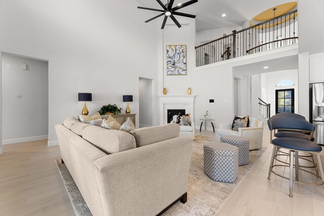 454 Patina Dr, Montgomery, TX 77316 - living area with a high ceiling, light wood-type flooring, ceiling fan, baseboards, and stairs