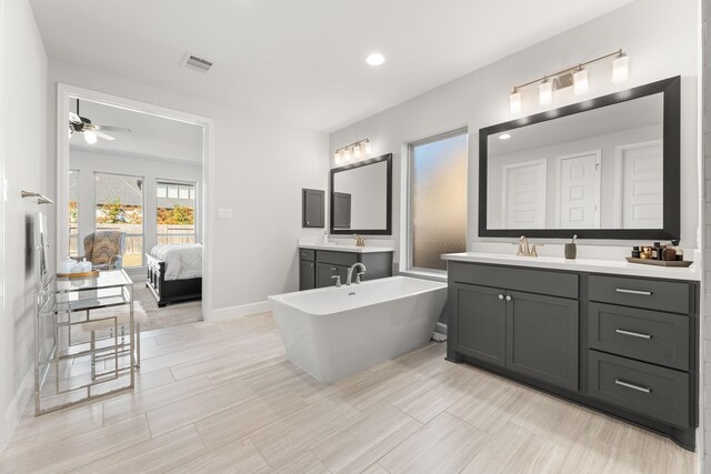 454 Patina Dr, Montgomery, TX 77316 - full bath with two vanities, a soaking tub, baseboards, recessed lighting, and a ceiling fan