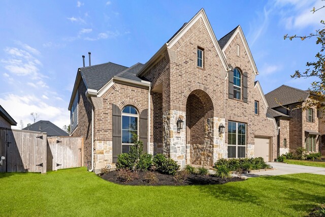 454 Patina Dr, Montgomery, TX 77316 - french country home with brick siding, concrete driveway, stone siding, an attached garage, and roof with shingles