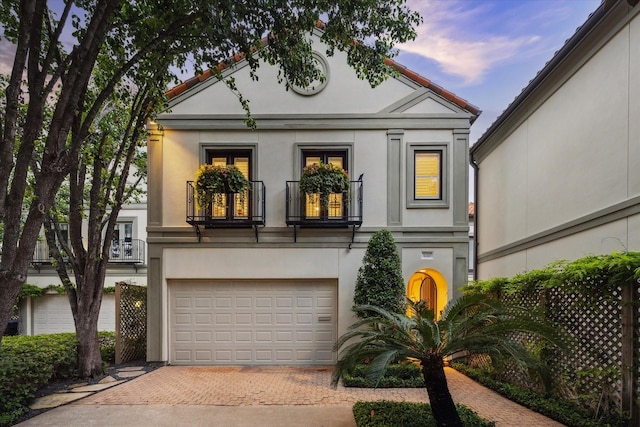 5710 Logan Ln, Houston, TX 77007 - neoclassical / greek revival house with decorative driveway, stucco siding, and an attached garage