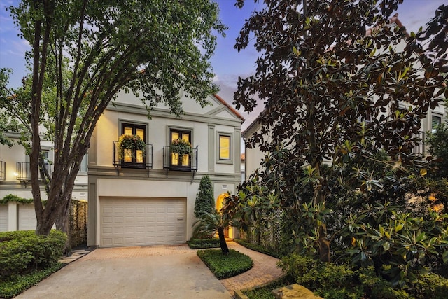 5710 Logan Ln, Houston, TX 77007 - view of front of home featuring concrete driveway, stucco siding, and an attached garage