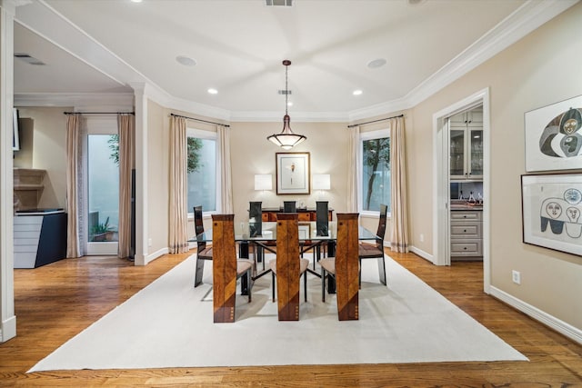 5710 Logan Ln, Houston, TX 77007 - dining room with healthy amount of natural light, wood finished floors, recessed lighting, ornamental molding, and baseboards